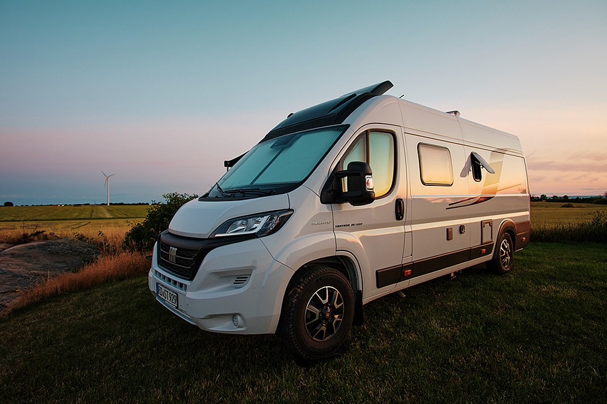 Ein weißes Wohnmobil der Marke Sunlight von hinten. Am Heck ist ein Fahrrad befestigt.