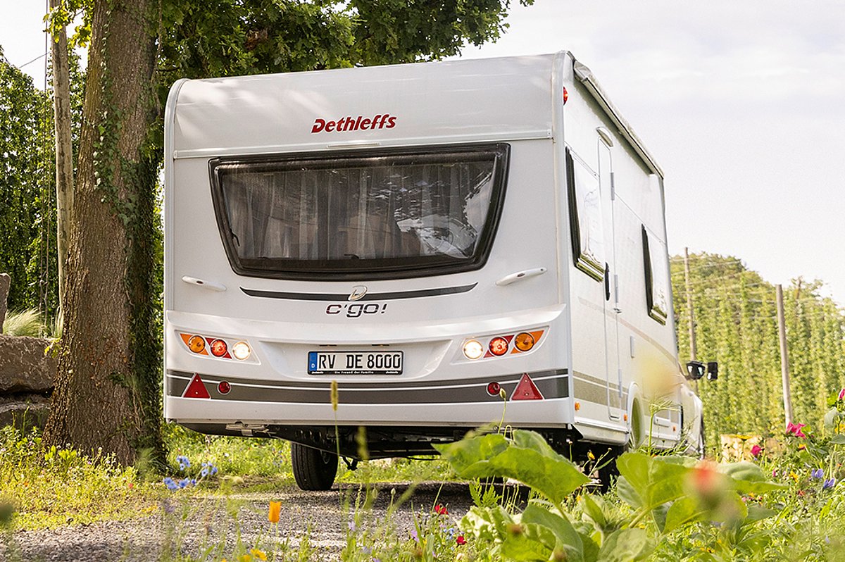 Ein Wohnwagen von hinten in der Landschaft.