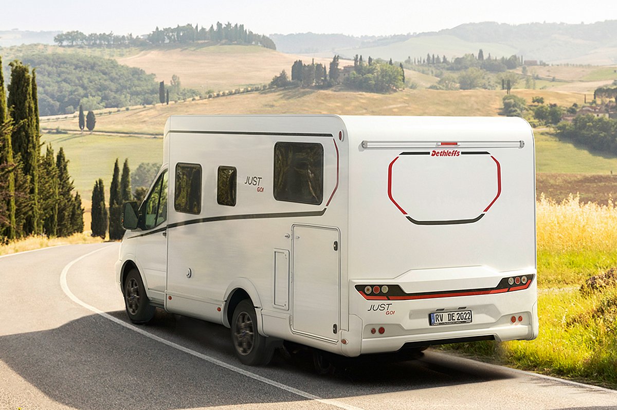 Ein Wohnmobil in einer Landschaft von schräg hinten.