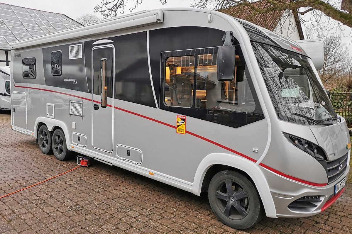 ein silbernes Wohnmobil von Dethleffs mit roten Details.