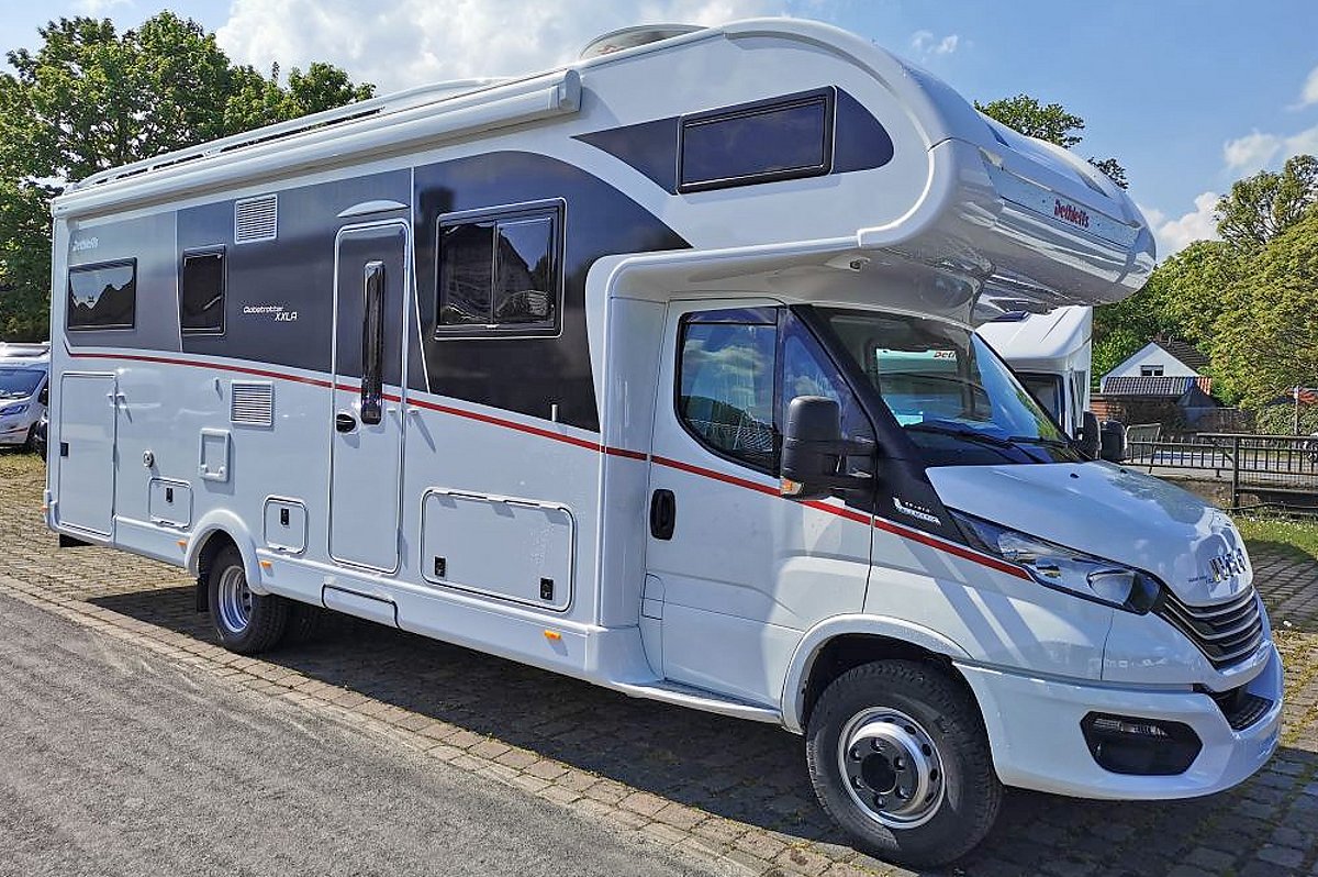 Ein weißes Alkoven-Wohnmobil auf dem Firmengelände von Caravanzeit.