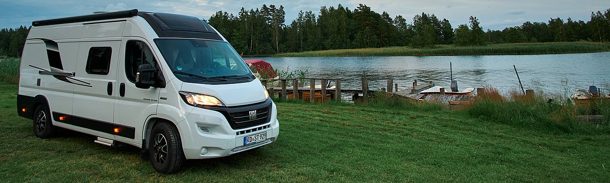 Ein Wohnmobil der Marke Sunlight vor einer Bergkulisse.